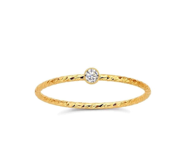 Gold filled bezel ring with a clear centerpiece stone, set in a gold-filled band.